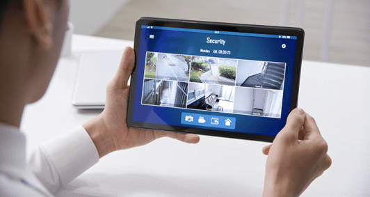 man holding tablet with home security images